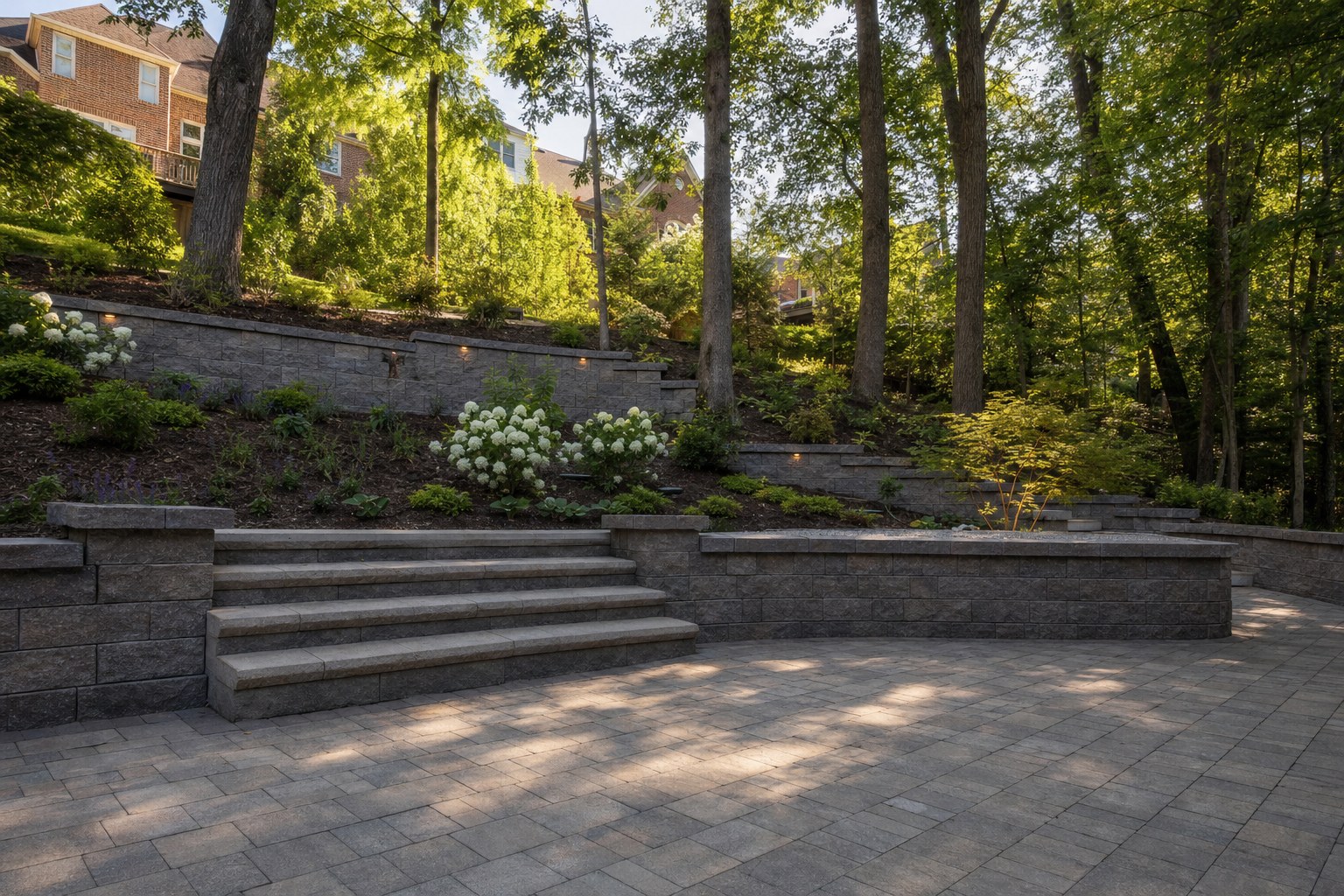 Terraced retaining walls and paver patio in a wooded South Hills backyard